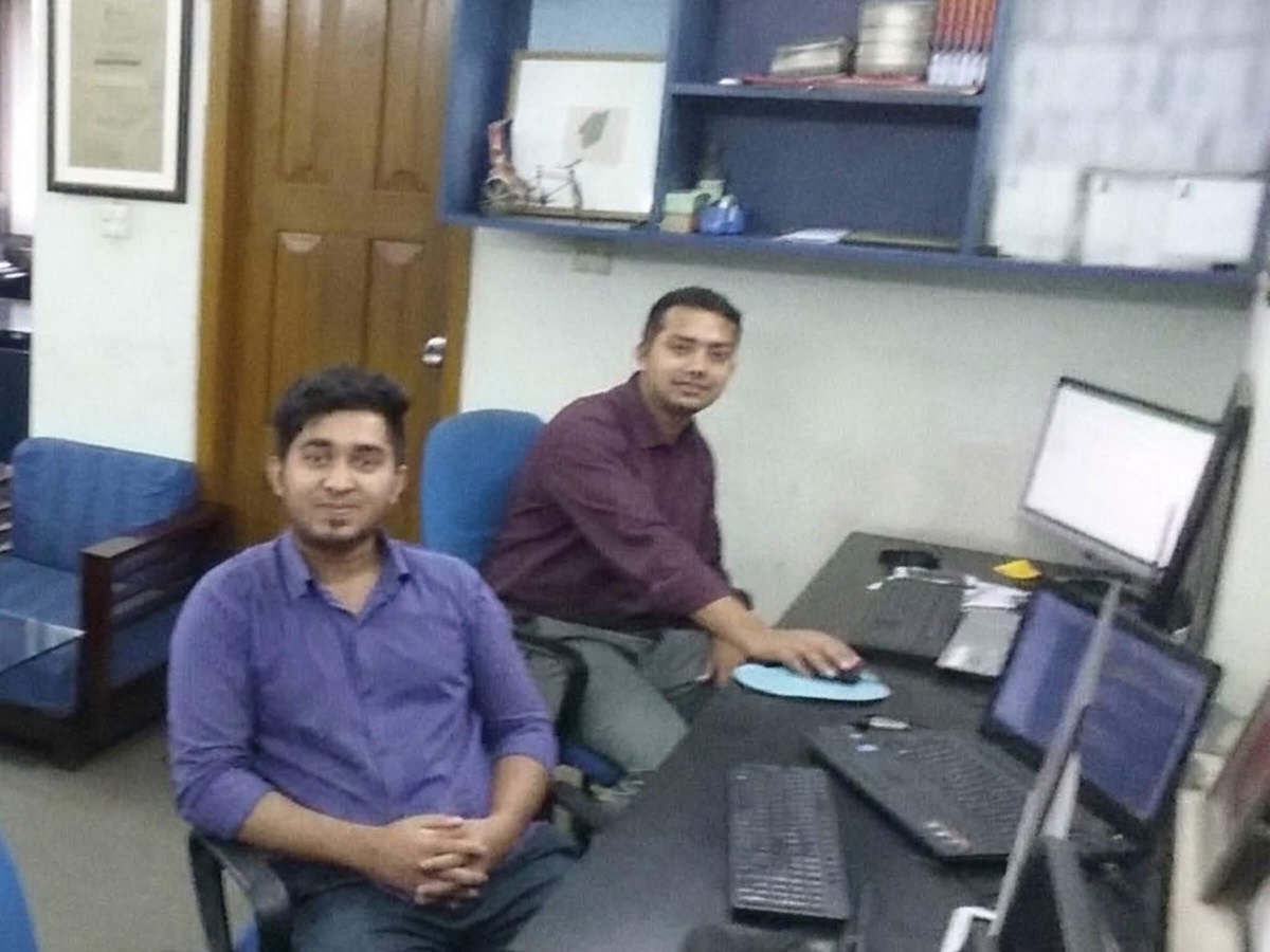 Ashekur Rahman and a colleague at their desks in the Quomodosoft office in 2017, monitors and laptops in front of them